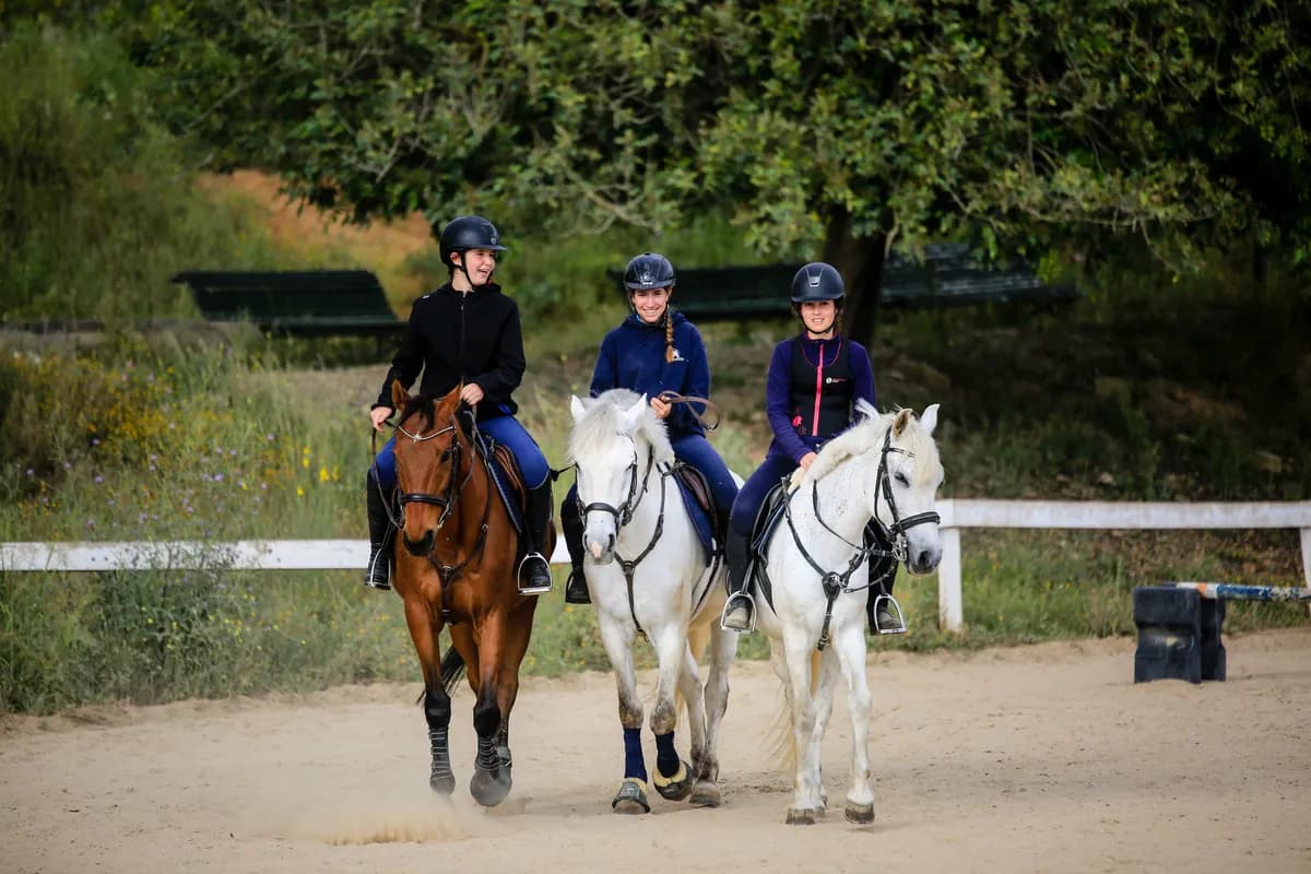 Tres alumnes a cavall durant una classe